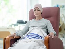 A middle-aged woman in a reclining chair receiving chemotherapy