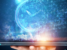 A hand is holding a tablet. Illuminating from the table is the image of a clock. This abstract image conveys how technology is helping monitor disease and predict the course of cancer over time.  