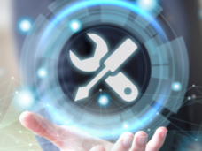 Holographic icon of a wrench and screwdriver tools hovering over an outstretched hand, with floating data points.