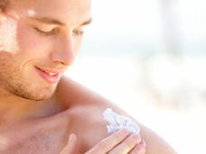 Young male applying sunscreen