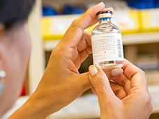 Pharmacist examining a drug vial.