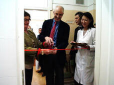 Ted Trimble cutting a ribbon at an opening ceremony.