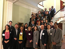 A group of diverse scientists standing indoors on a staircase.