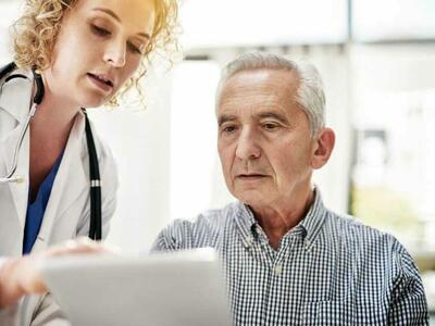 A medical professional and patient reviewing information on paper. 