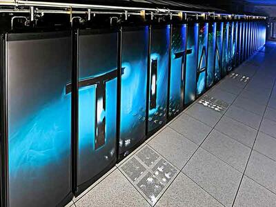 A row of grey Metallica structures connected by metal at the top. The word “TITAN” runs across the front of the metal structures and a bluish glow emits from the background. The floor is made of grey tile.