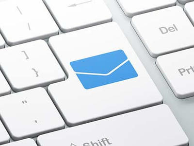 A close-up of the return key on a keyboard. A blue envelope icon replaces any text that might normally be found on this key.