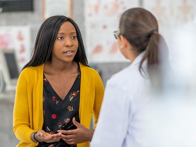Young woman speaking with a physician.