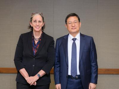 Dr. Kimryn Rathmell and Dr. Seogyoun Kang standing together in front a table.