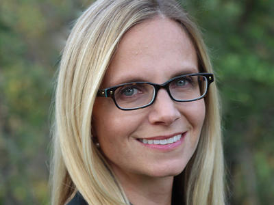 Photo of Dr. Christina Curtis wearing black glasses and a black sleeveless blouse. 