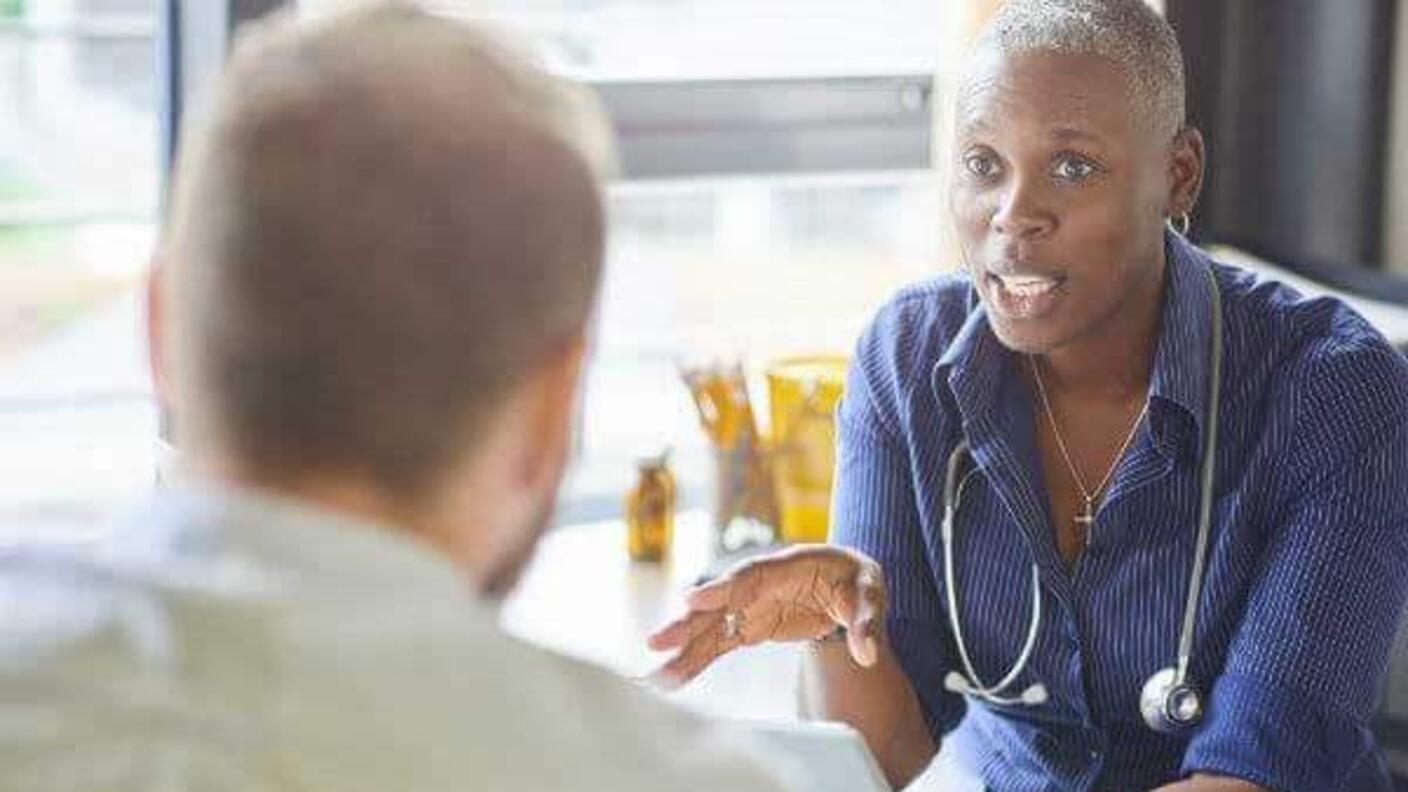A female doctor speaking with a male patient.