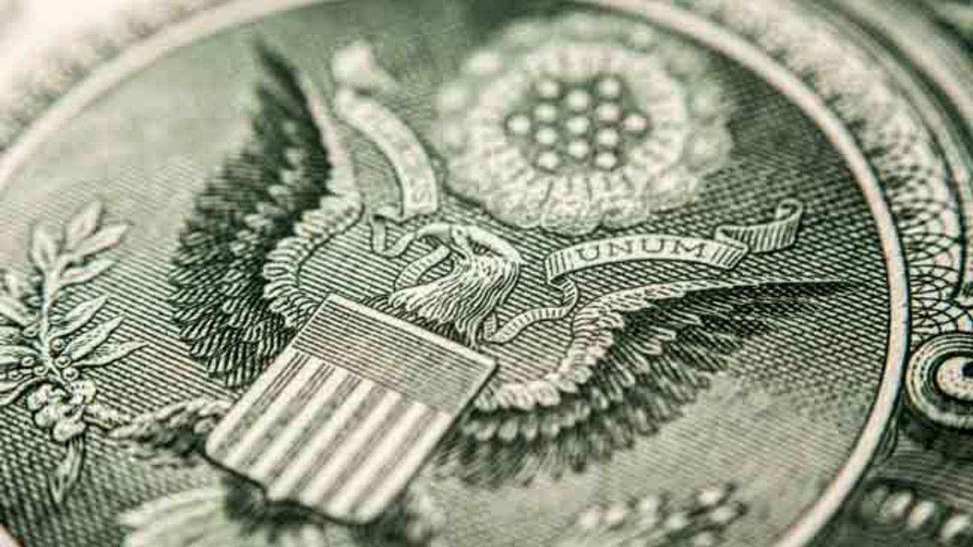 A close-up image of the seal of the United States on a US dollar bill. 