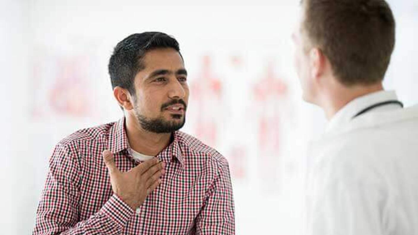 A person having a conversation with a doctor in a medical office.
