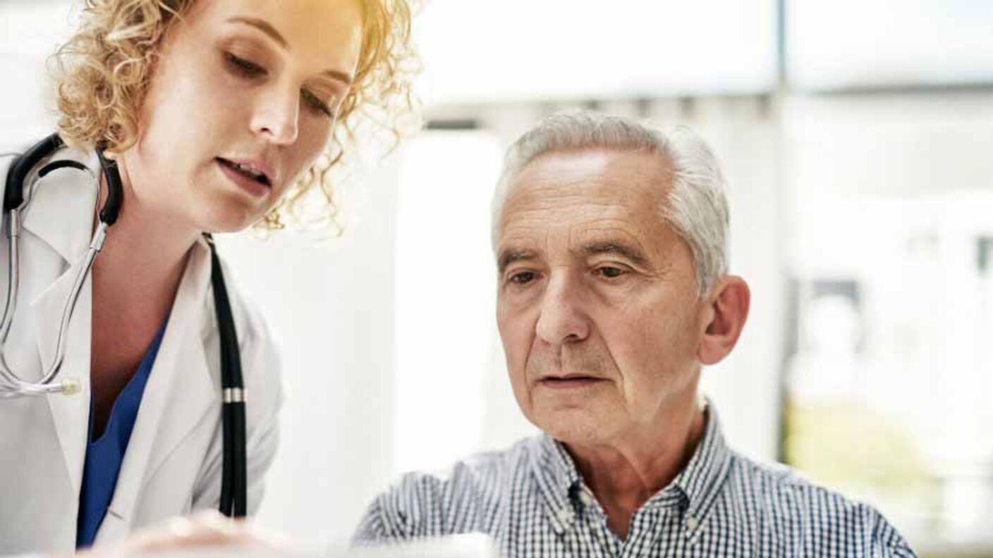 A medical professional and patient reviewing information on paper. 