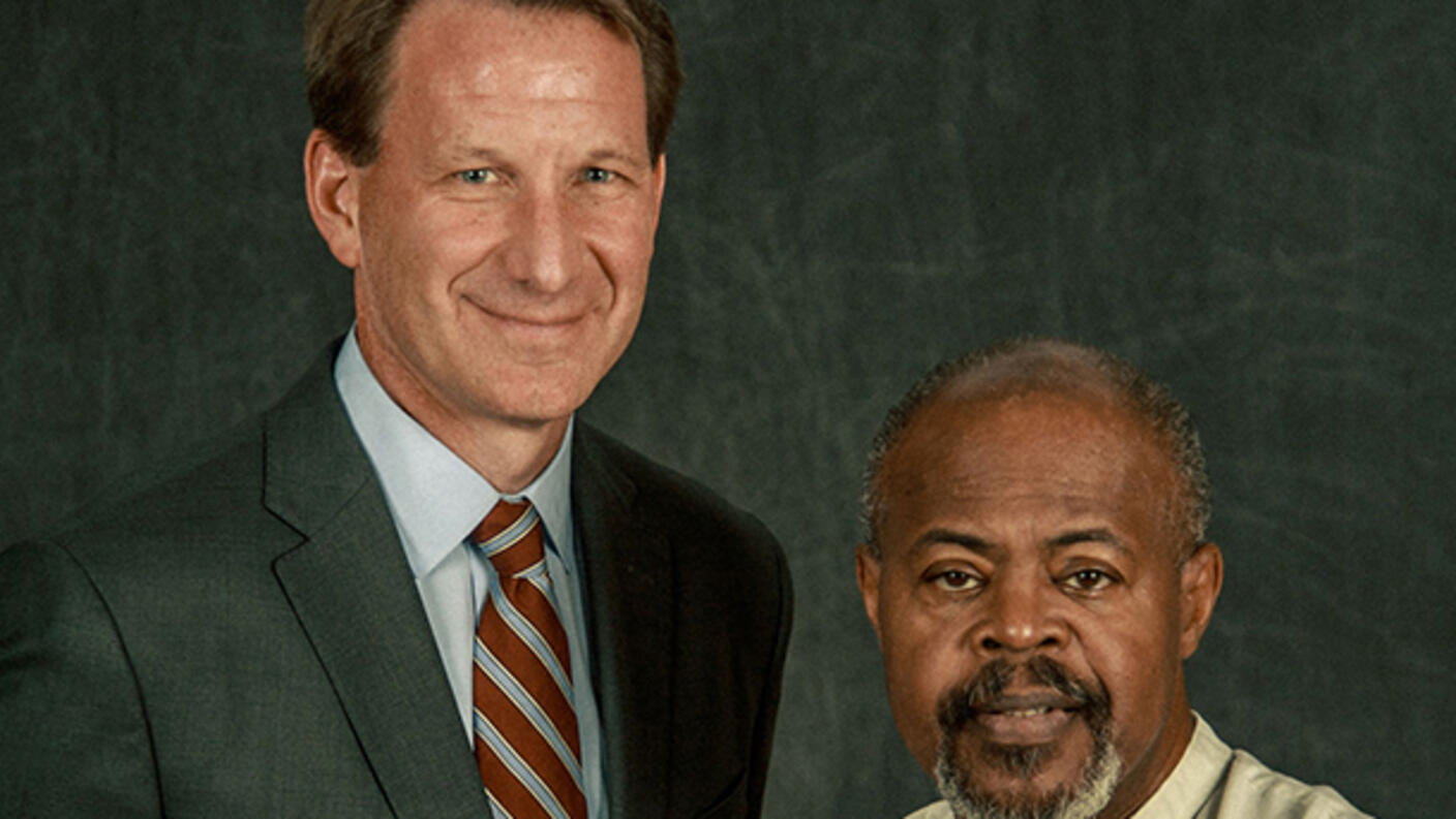 Dr. Sharpless and a former patient, Mike together in a photo studio with a dark backdrop