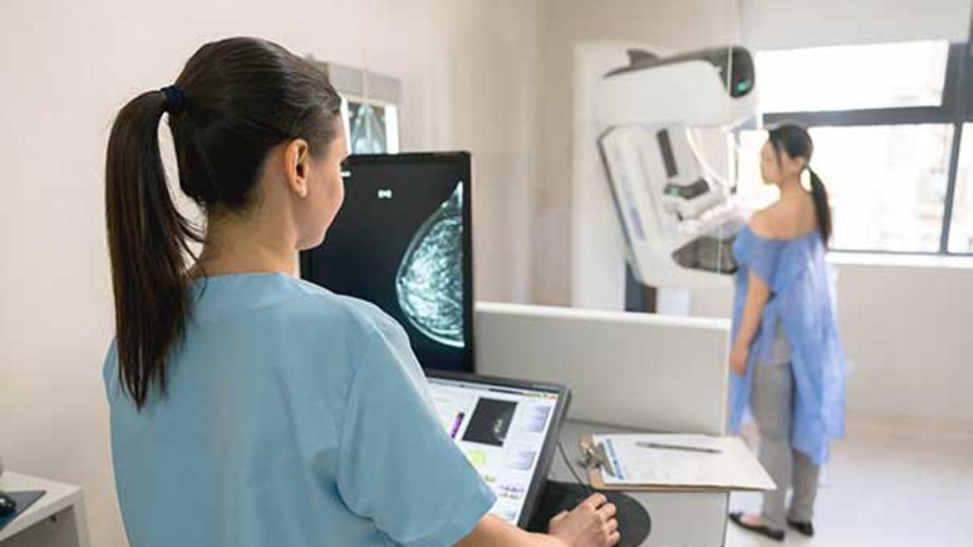 Woman undergoes mammography with health care provider.