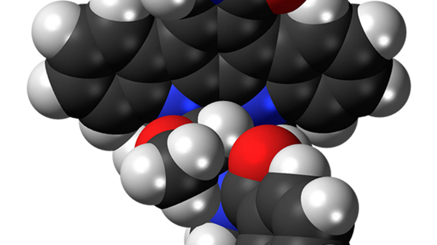 3D molecular model of midostaurin, an FDA-approved drug for treating certain patients with acute myeloid leukemia, showing black carbon atoms, white hydrogen atoms, blue nitrogen atoms, and red oxygen atoms connected in a complex molecular structure.