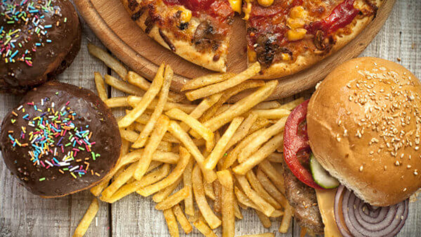 Image of high fat foods including donuts, french fries, cheeseburger, and pizza.
