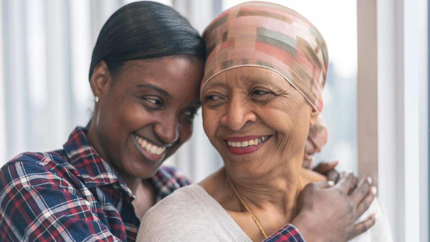 African-American daughter hugging mother and smiling