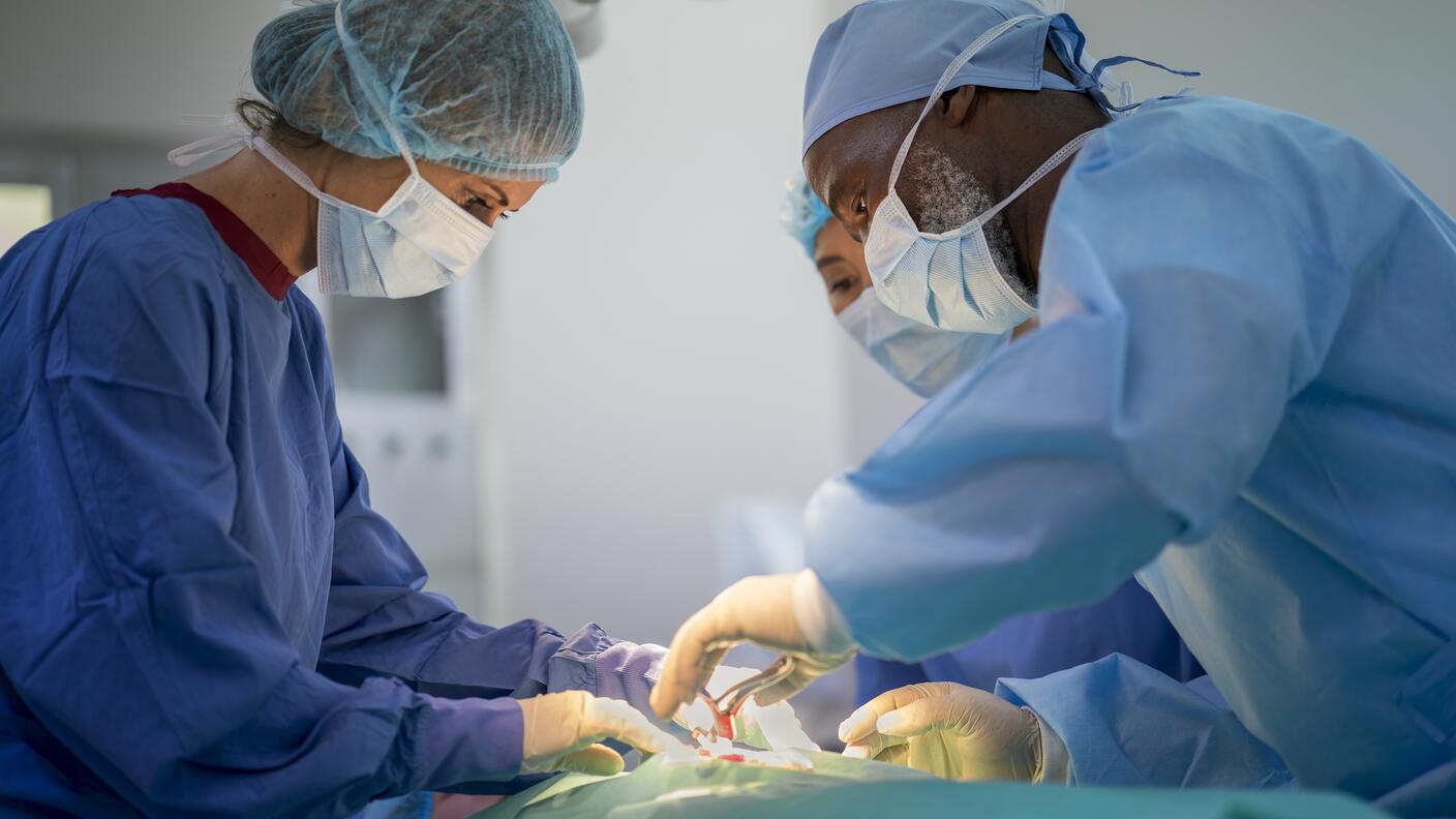 Photo of doctors performing surgery in a hospital operating room.