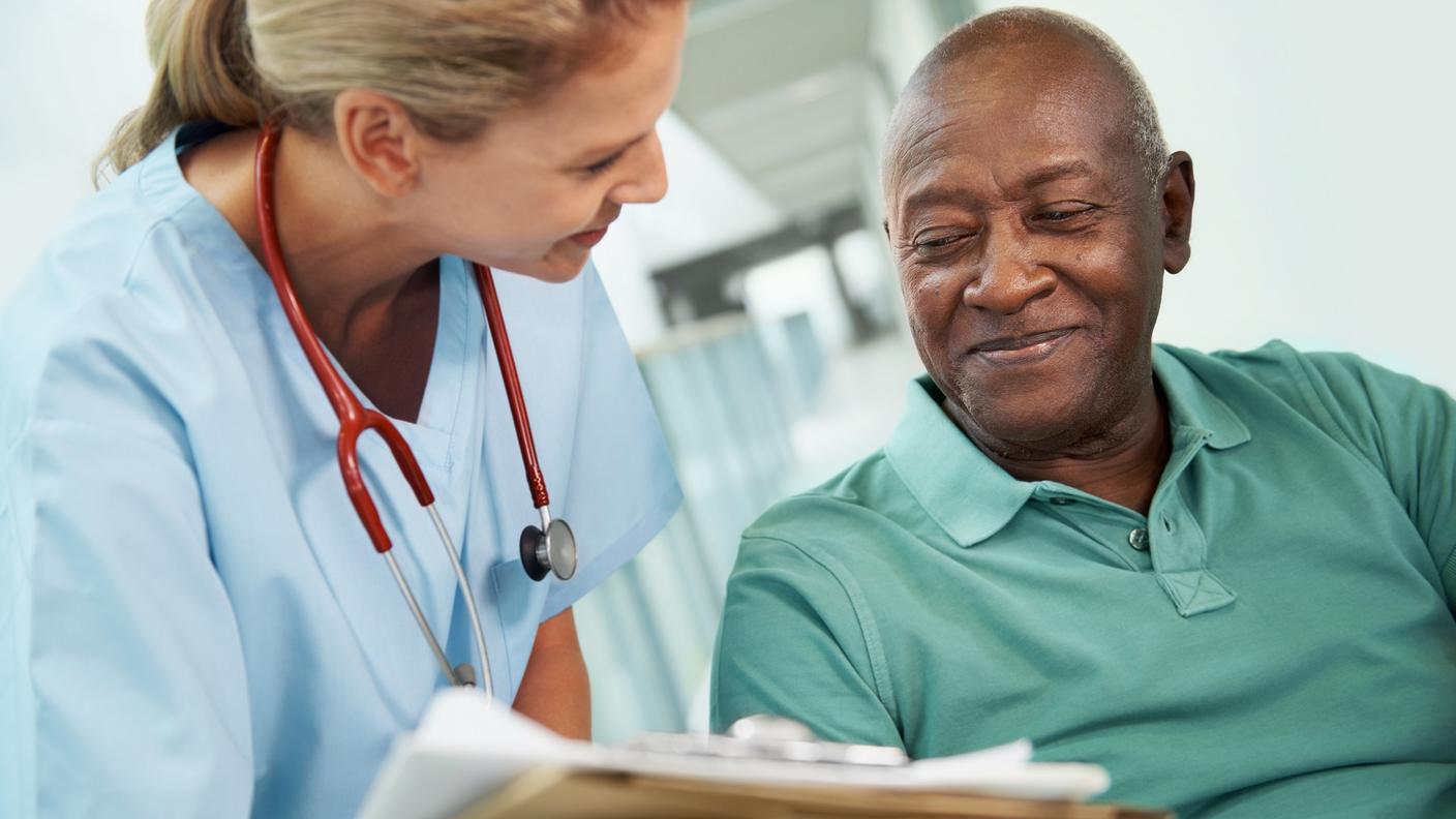 A nurse showing an African American man his test results.