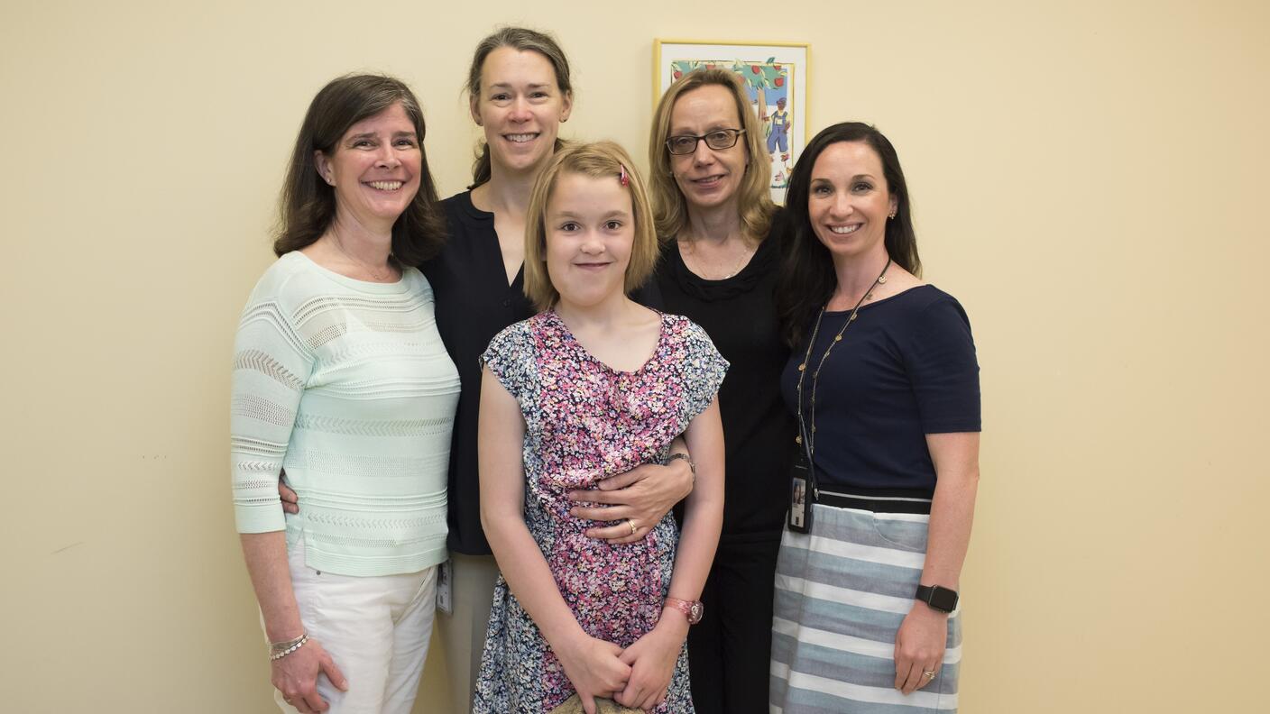 Members of the Pediatric Oncology Branch at the National Cancer Institute's Center for Cancer Research (CCR) gather with their young patient Jane and Jane's mother Kristina. Jane received treatment at CCR for a rare cancer called neurofibromatosis type 1 (NF1). Shown from left to right: Trish Whitcomb, RN; Kristina; Jane; Brigitte Widemann, M.D. (branch chief); and Andrea Baldwin, CRNP.