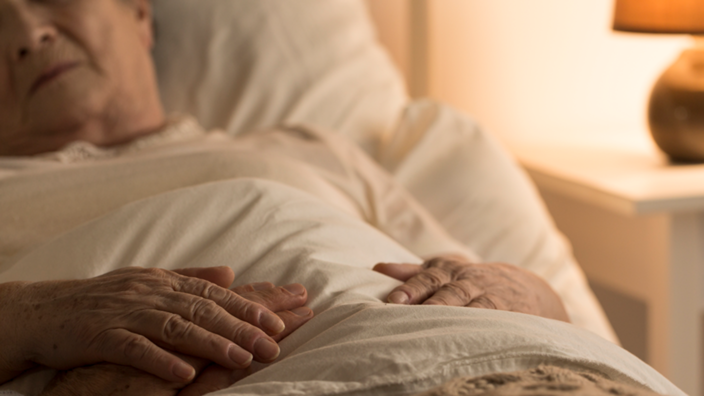 A sick man in a hospital bed.