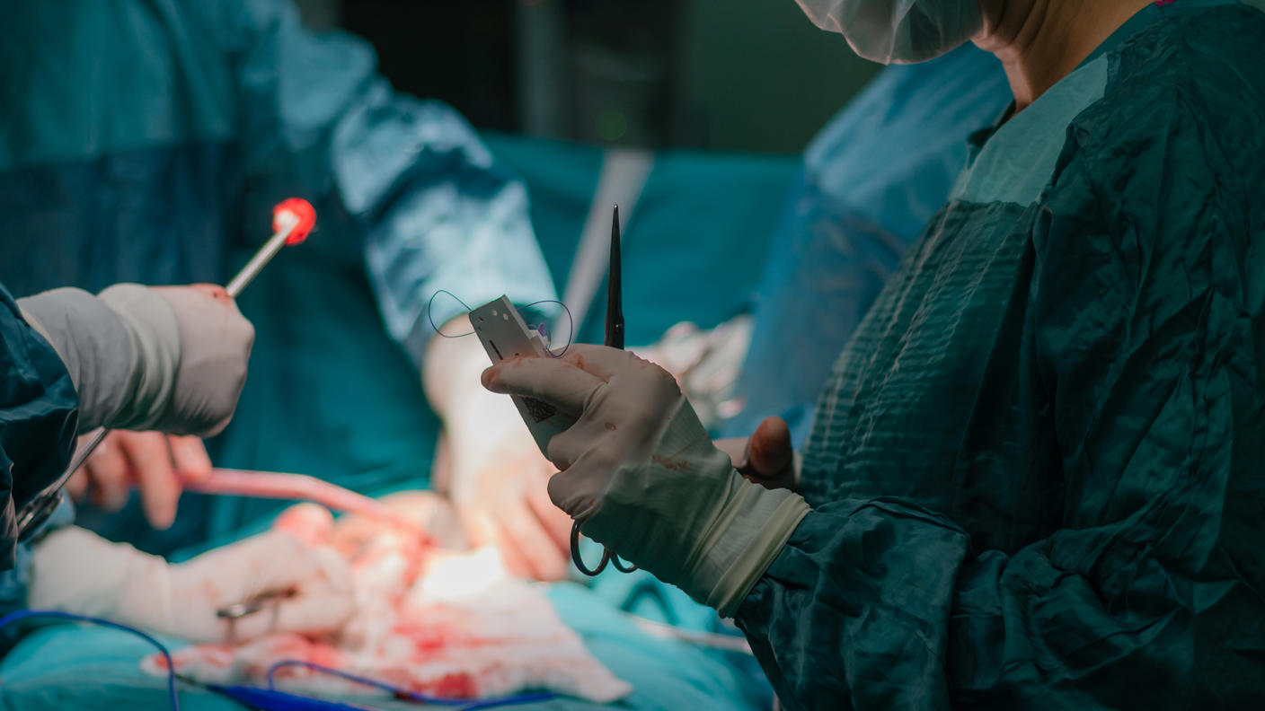 Un equipo quirúrgico al rededor de un paciente en una sala de operaciones