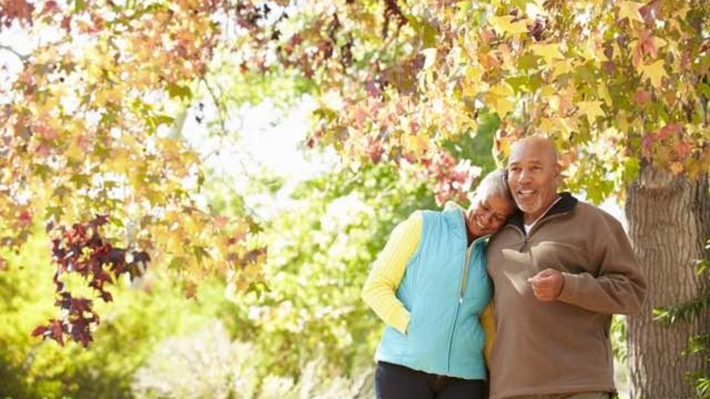 Man and woman standing under a tree in autumn