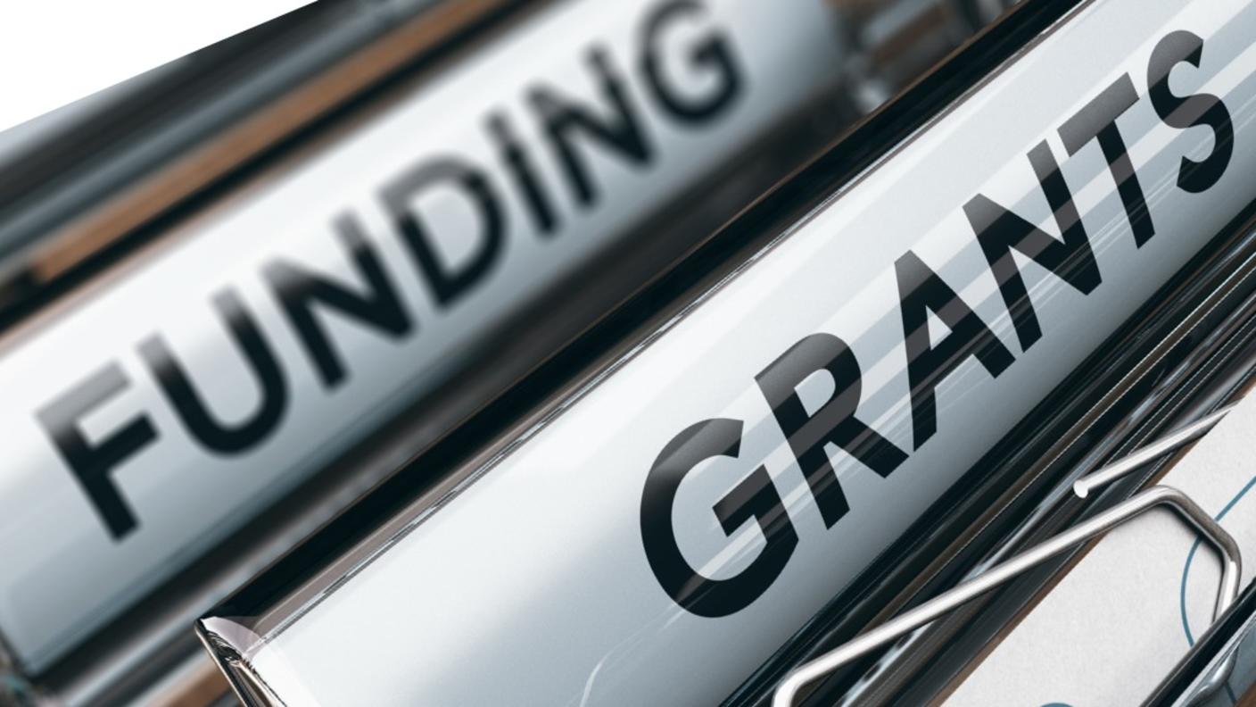 Office manila folders showing funding and grants labels.