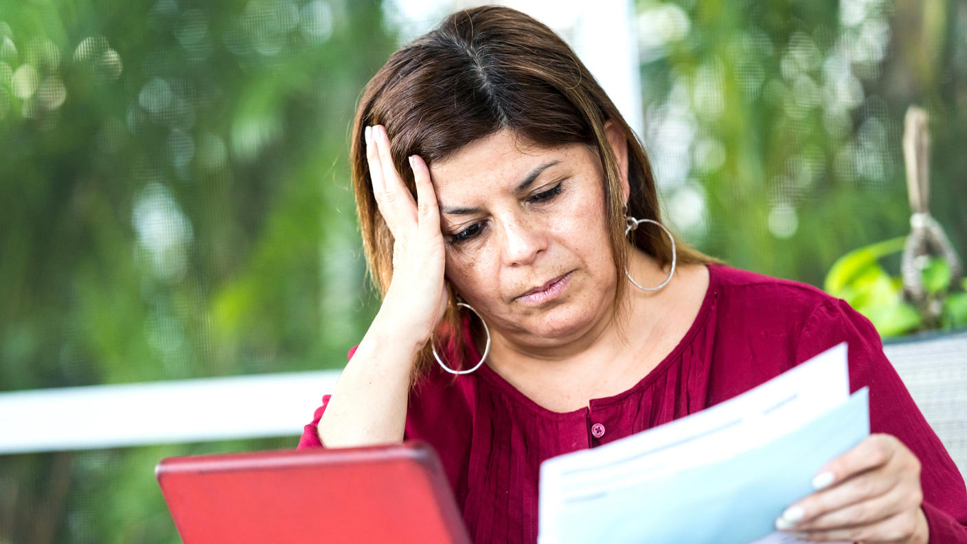 Mujer hispana que se ve preocupada por sus recibos que tiene que pagar