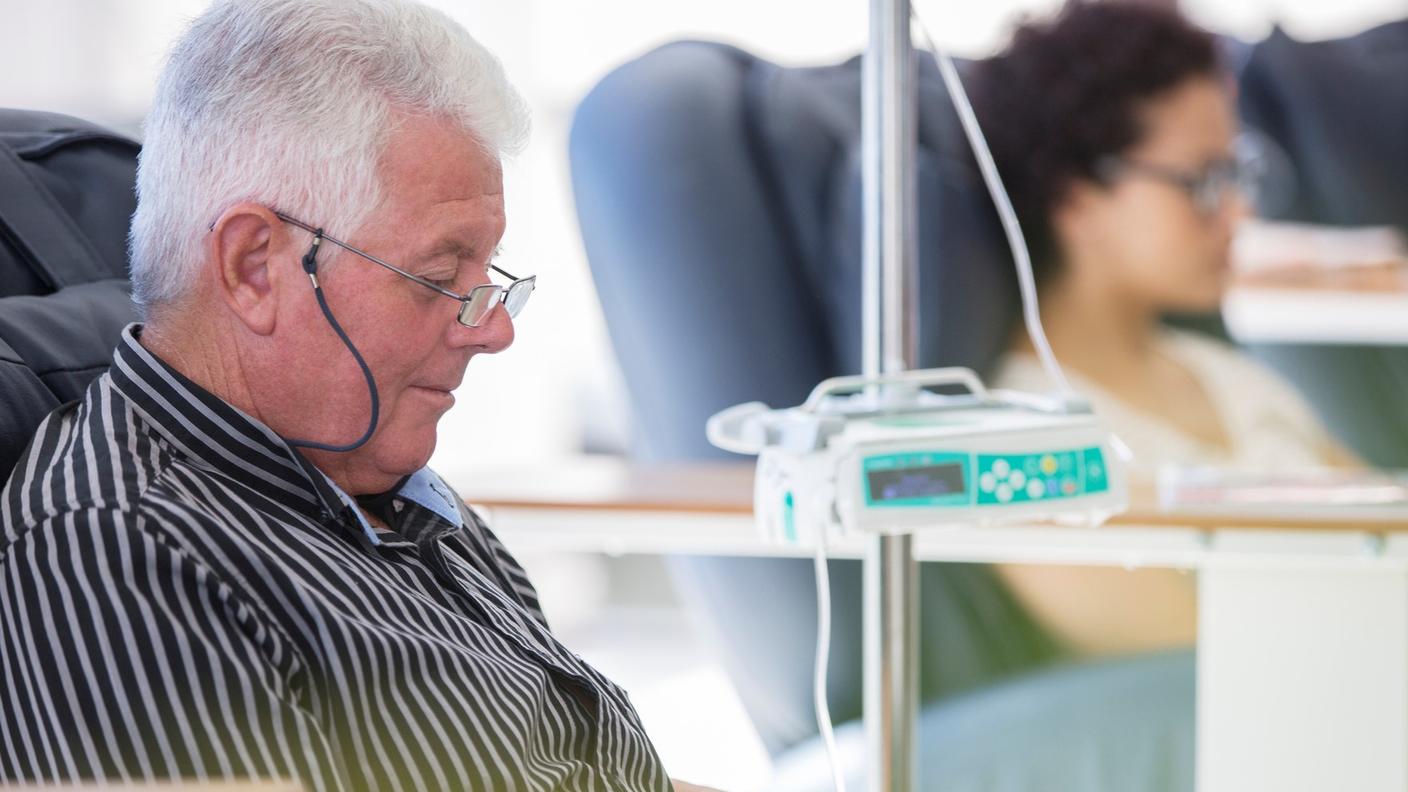 An older man in a recliner receiving outpatient IV cancer medication