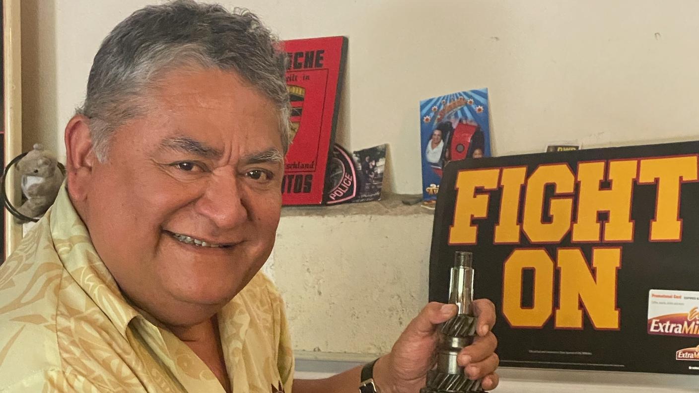 A picture of Adan Reinosa in his garage with a piece of a car engine.