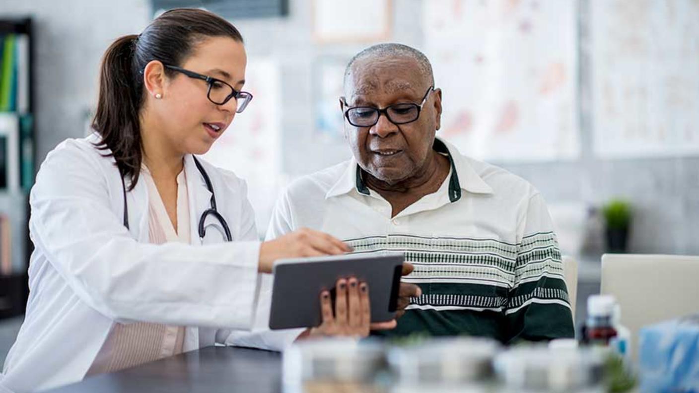 Doctor and patient looking at a tablet computer. 