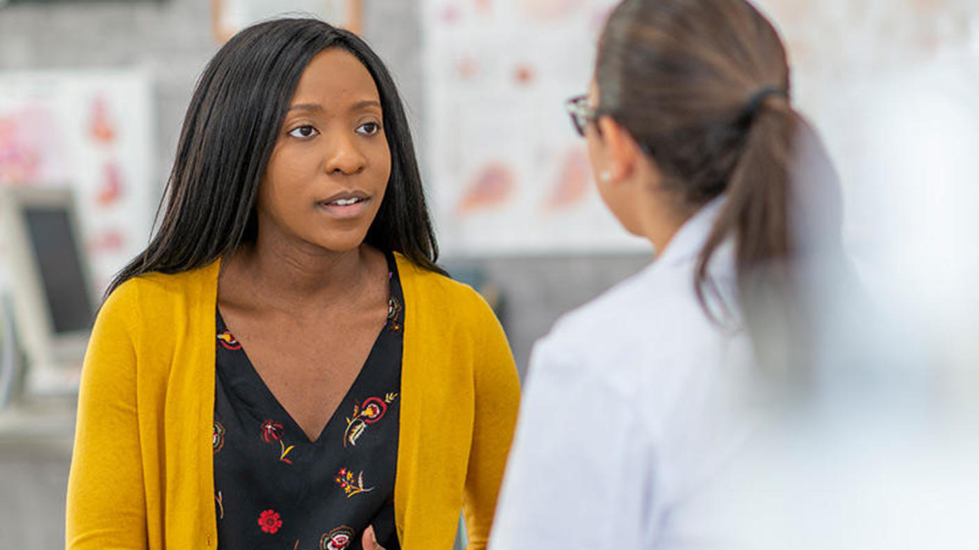 Una joven conversa con una médica.