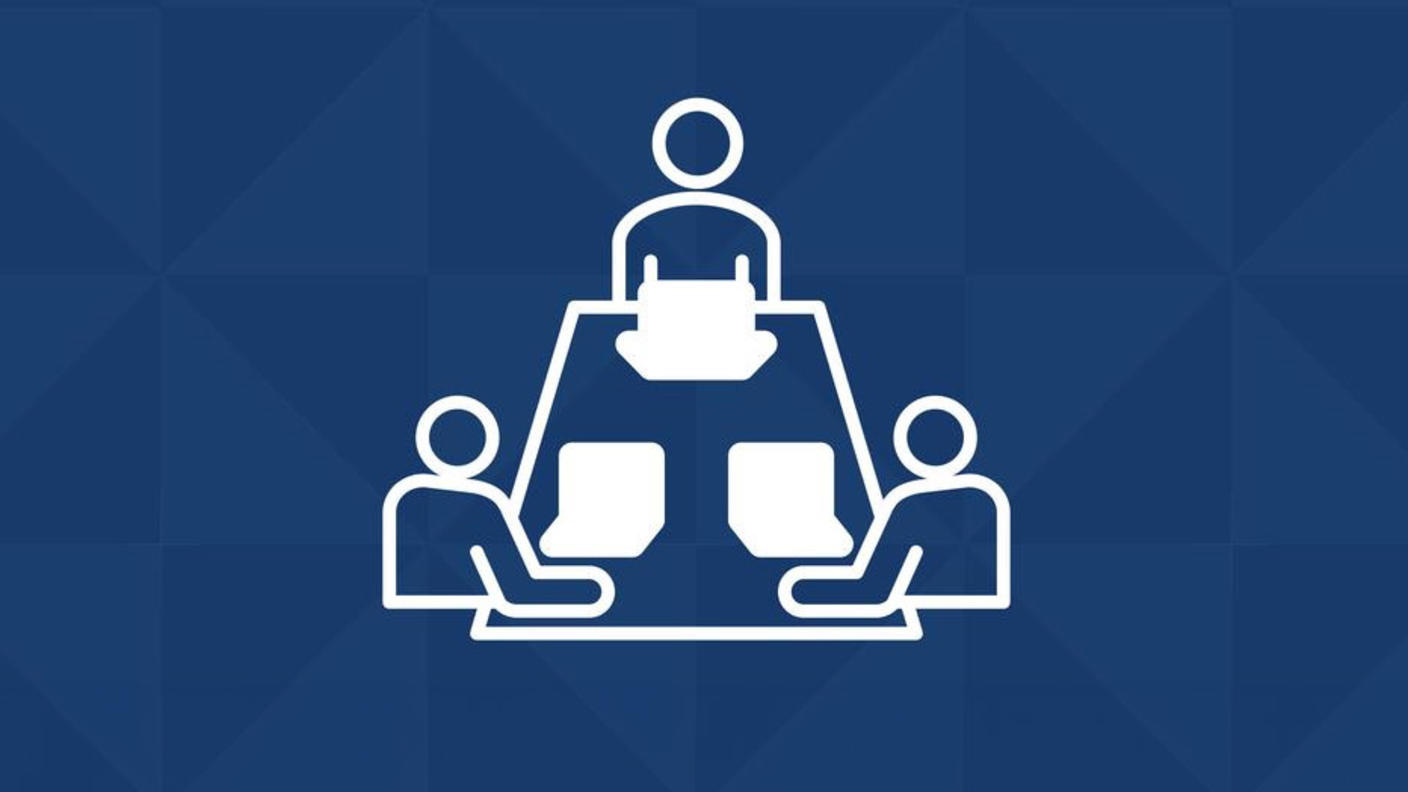Icon graphic of three people sitting at a rectangular table with laptops.