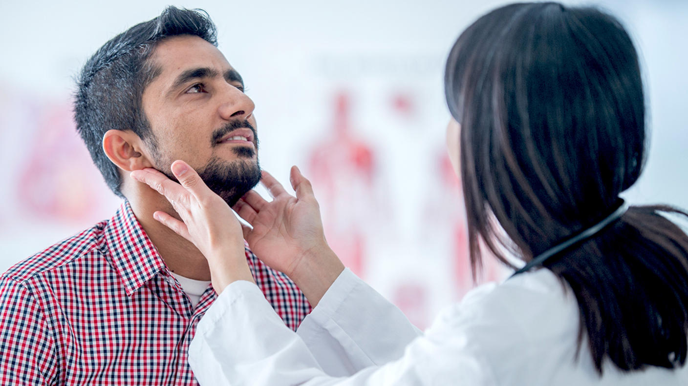 A female physician checking a man for cancer symptoms. 