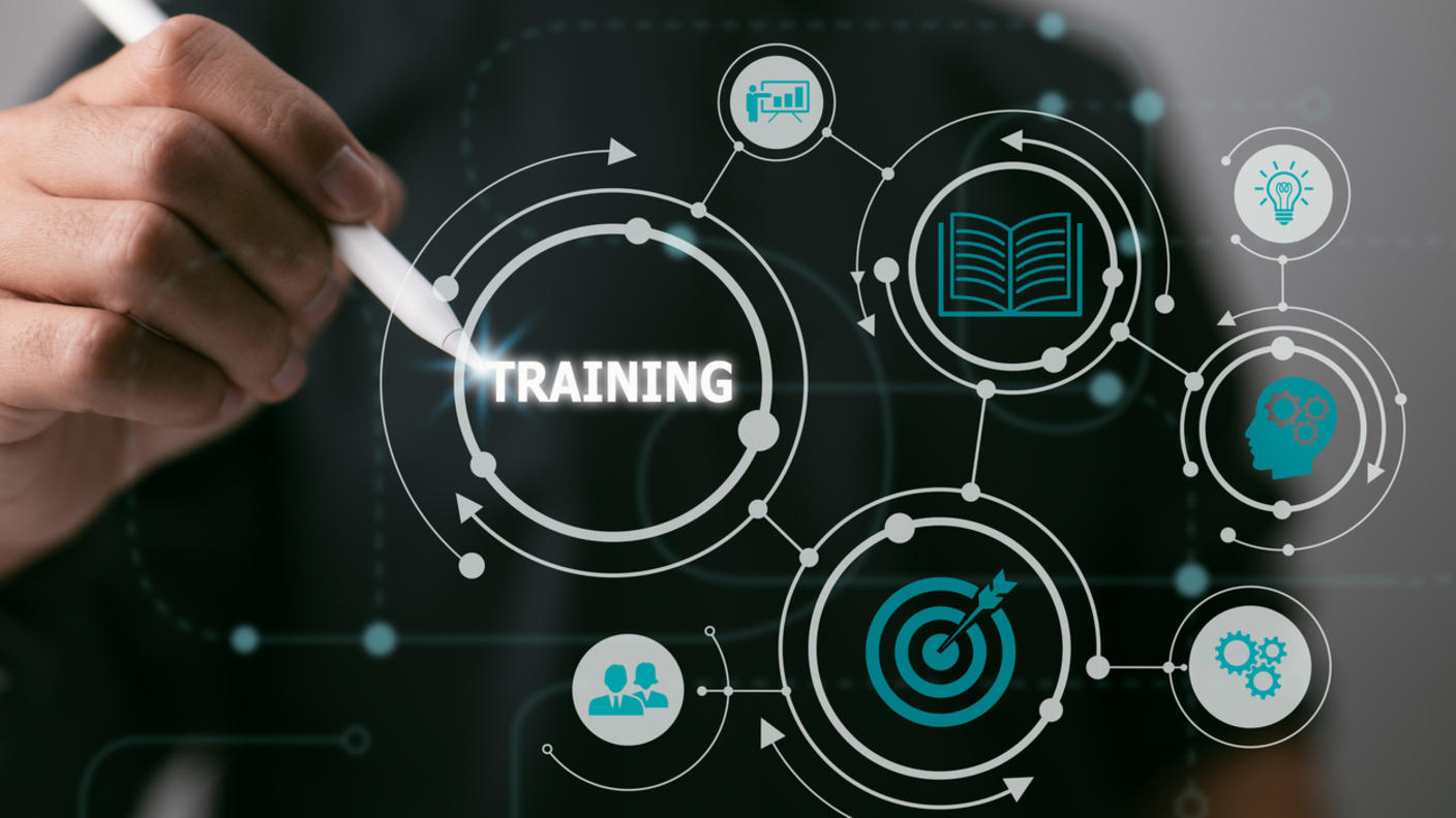 A hand to the word "training" with a pen. The word "training" is connect to icons of a person presenting, a book, a lightbulb, gears, a bulls eye, and two business people.