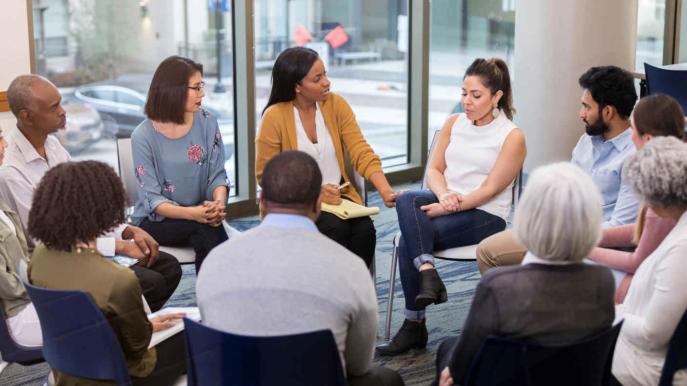 People sitting in a circle listening to each other talk.
