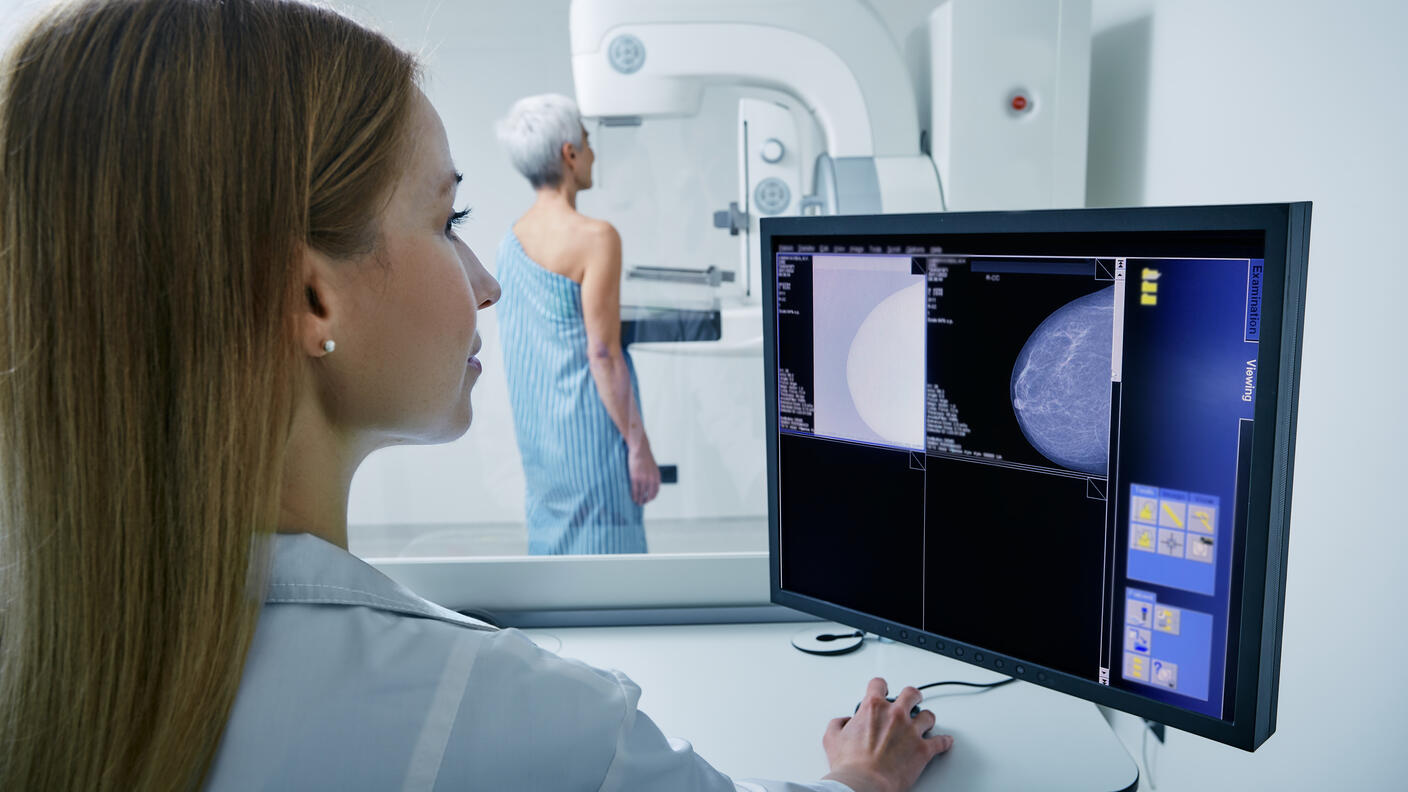 Medical technician taking mammogram exam to female patient. Mature woman undergoing breast screening or mammography
