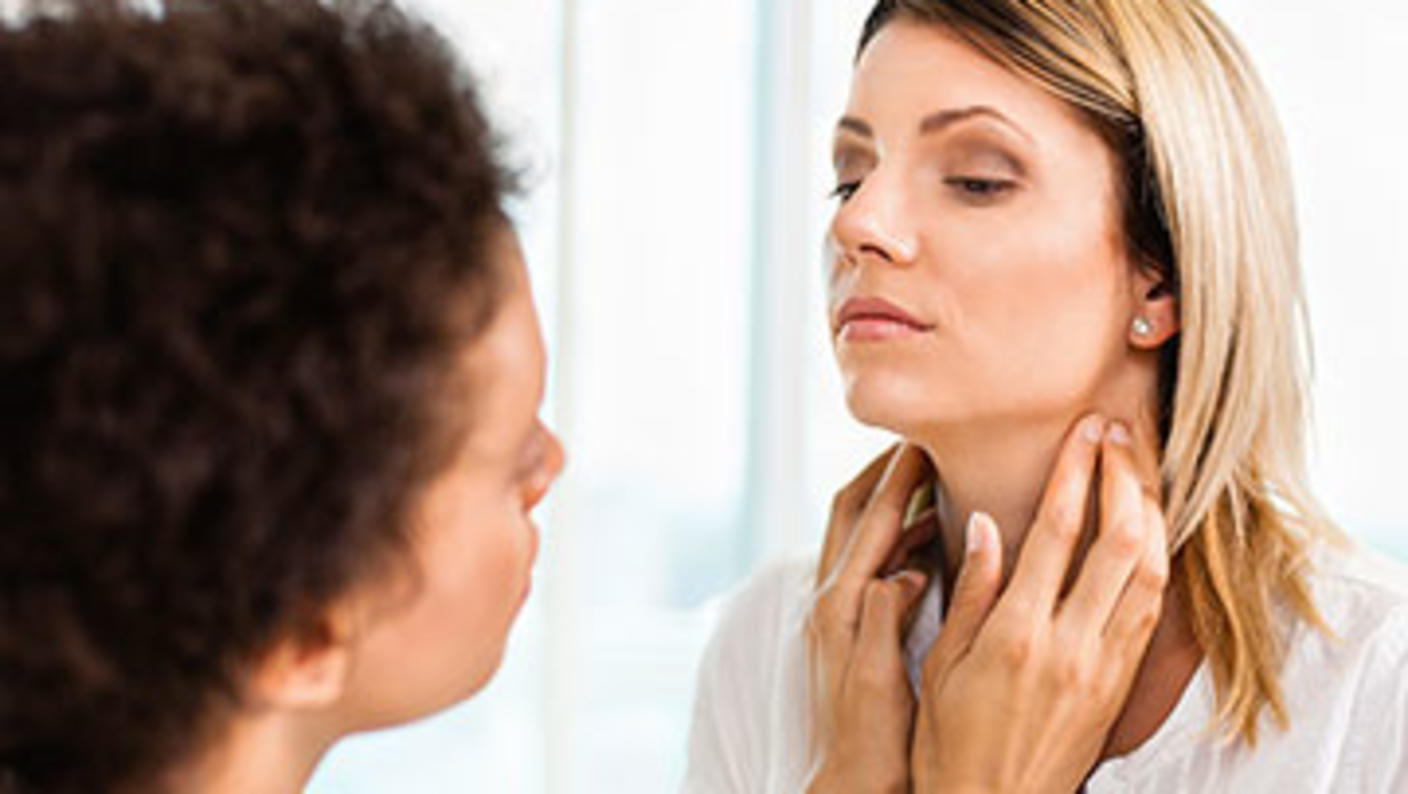 Young woman receiving thyroid exam from her doctor