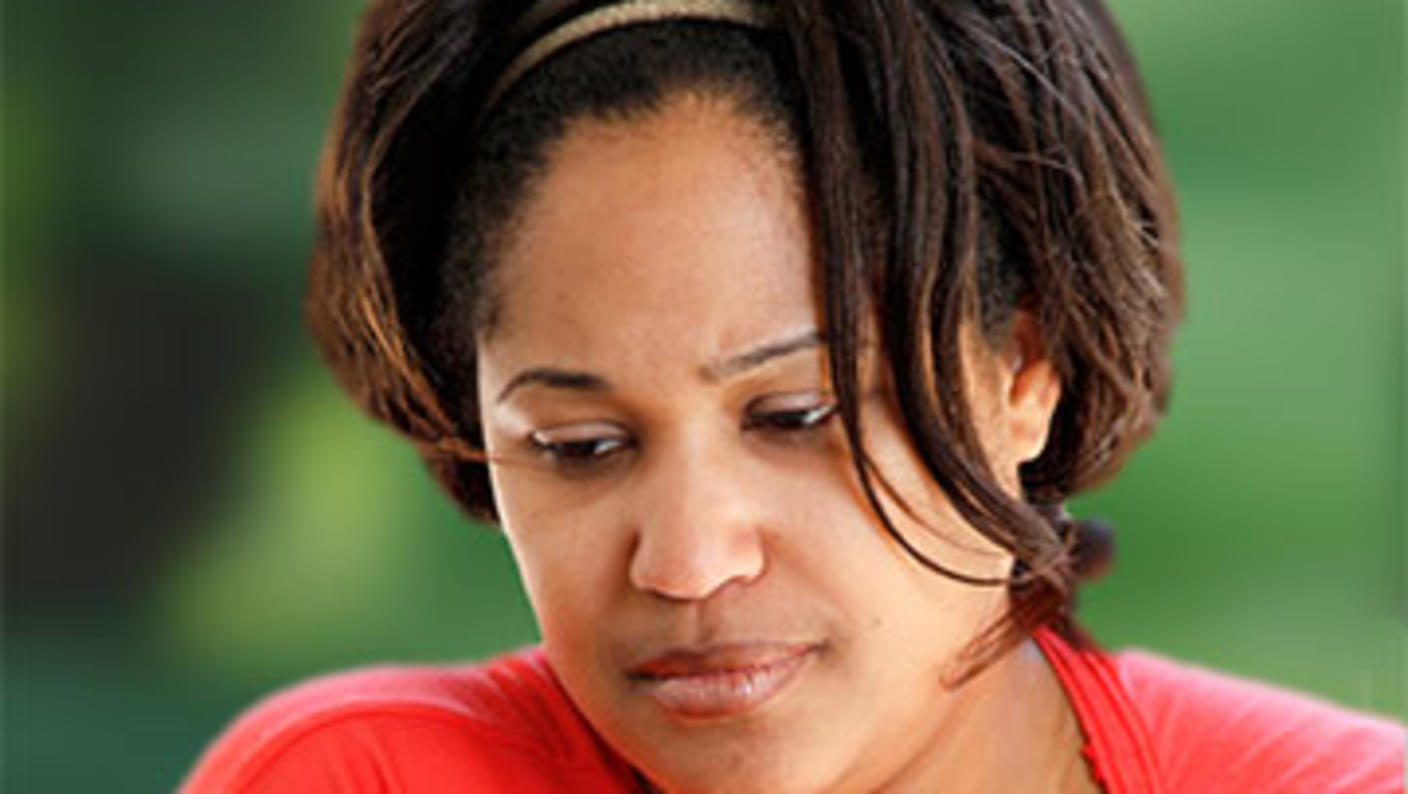 Headshot of woman with downcast eyes and sad expression.