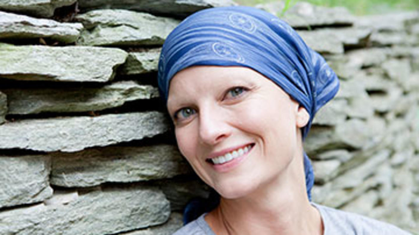 Smiling woman wearing head scarf.