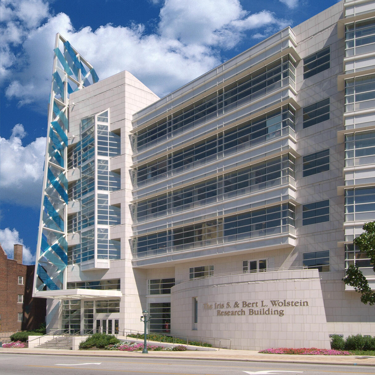 External view of Case Western Reserve University Case Comprehensive Cancer Center, a modern research building with a distinctive architectural design featuring large glass windows and clean white stone.