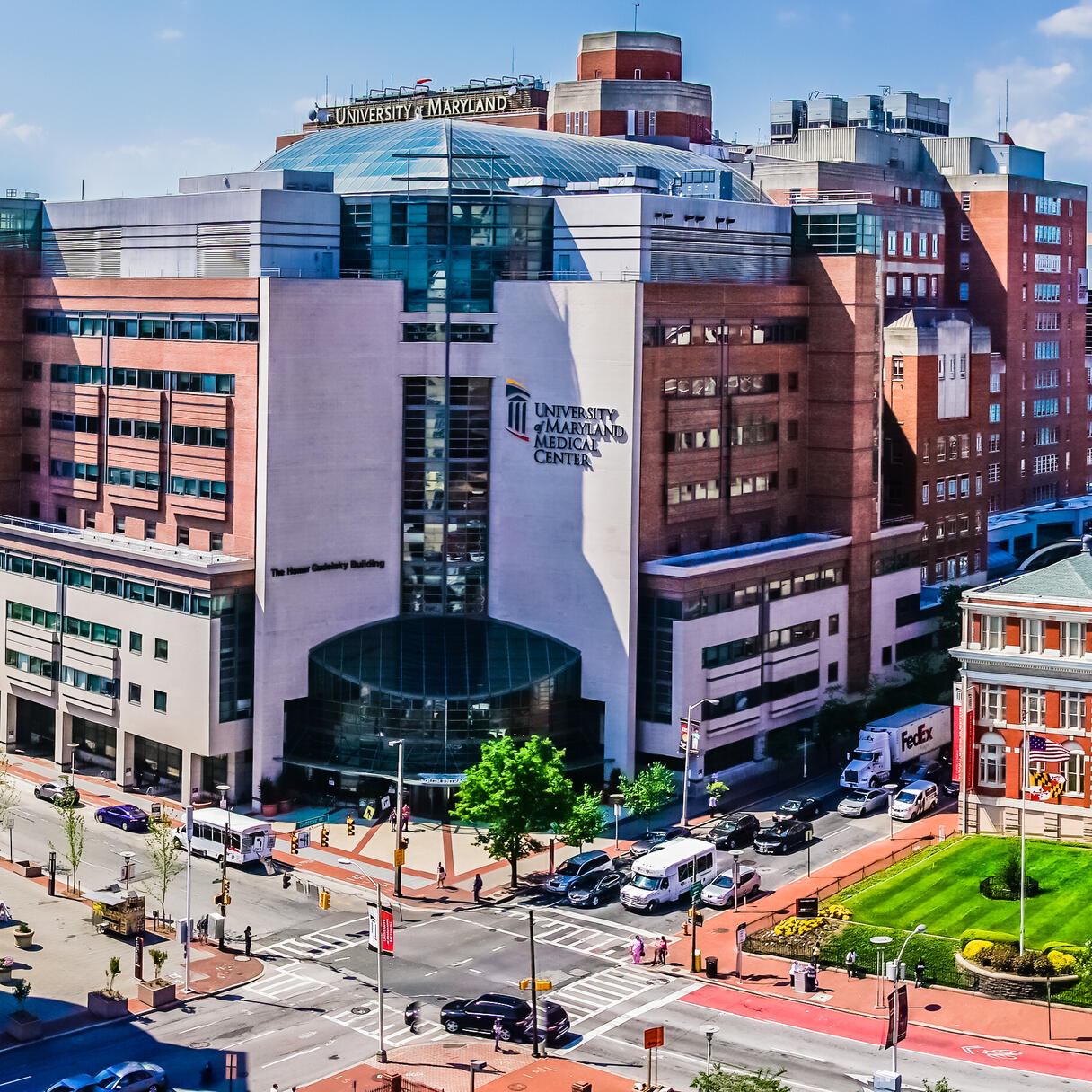 University of Maryland Greenebaum Cancer Center complex with surrounding city buildings and streets under a clear sky.