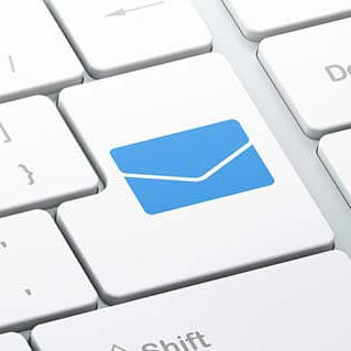 A close-up of the return key on a keyboard. A blue envelope icon replaces any text that might normally be found on this key.