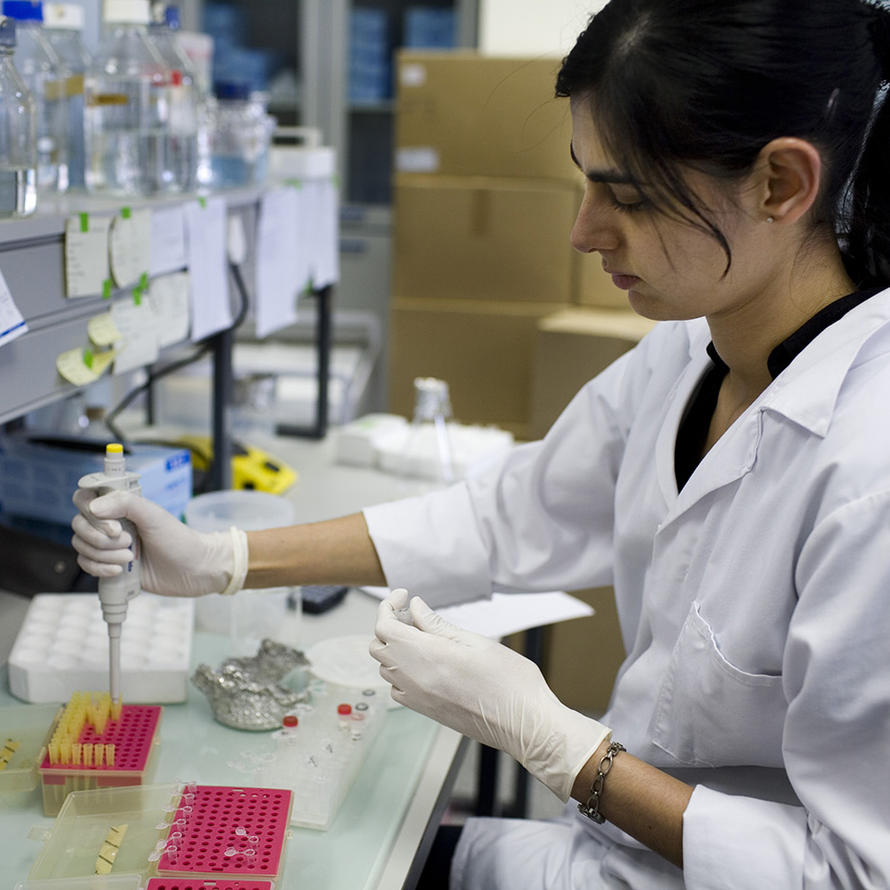 Female researcher in lab uses a pipette